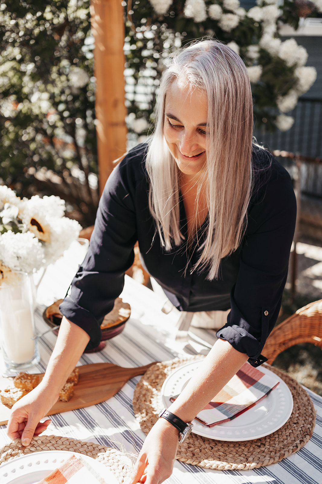 Woman setting an outdoor table for dinner